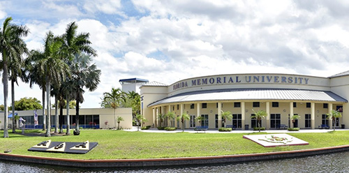 Florida Memorial University on a beautiful, clouded day, with scattered palm trees to the left.